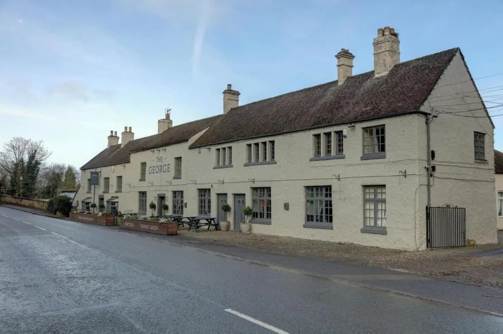 The George at Piercebridge, a long whitewashed coaching inn beside the road