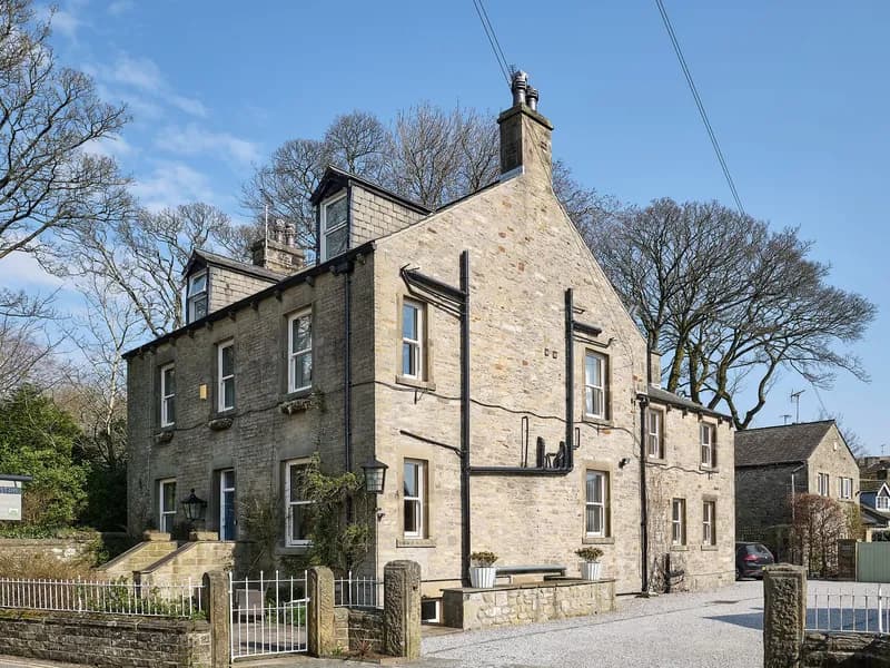 Grassington Lodge, a tall stone Dales house with a slate roof under a blue sky